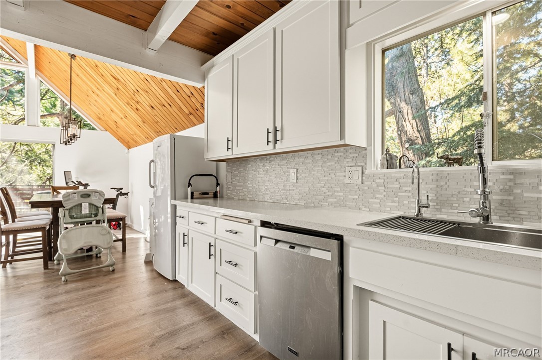 316 Pioneer Road Lake Arrowhead, CA 92352 - Photo 9 of 35 a kitchen with stainless steel appliances granite countertop a stove a sink and white cabinets with wooden floor