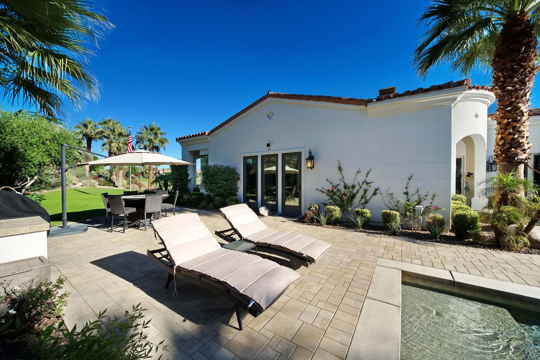 76054 Via Saturnia Indian Wells, CA 92210 - Photo 15 of 61 a view of a patio with table and chairs potted plants and palm trees
