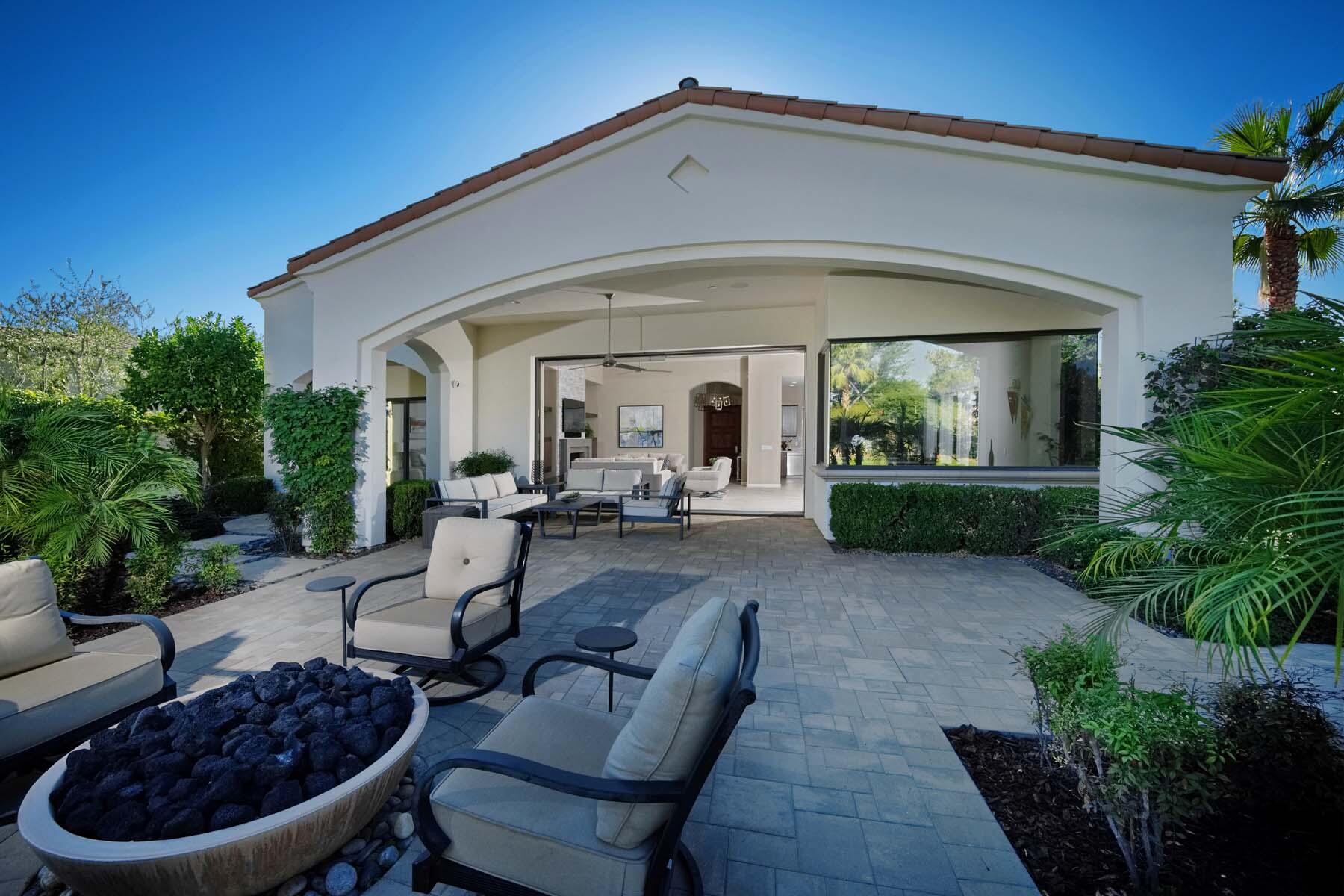 76054 Via Saturnia Indian Wells, CA 92210 - Photo 31 of 61 a view of a patio with couches table and chairs potted plants and palm tree