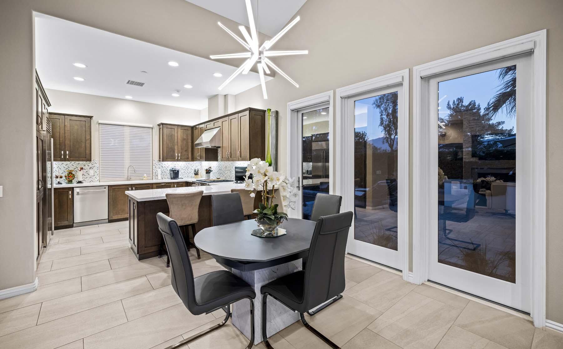 76054 Via Saturnia Indian Wells, CA 92210 - Photo 36 of 61 a open dining room with stainless steel appliances kitchen island granite countertop a refrigerator dining table and chairs