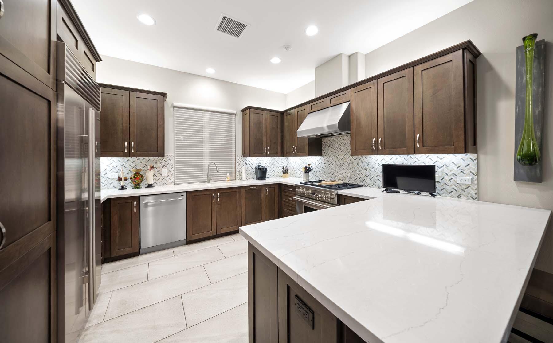 76054 Via Saturnia Indian Wells, CA 92210 - Photo 37 of 61 a large kitchen with kitchen island a sink stainless steel appliances and cabinets