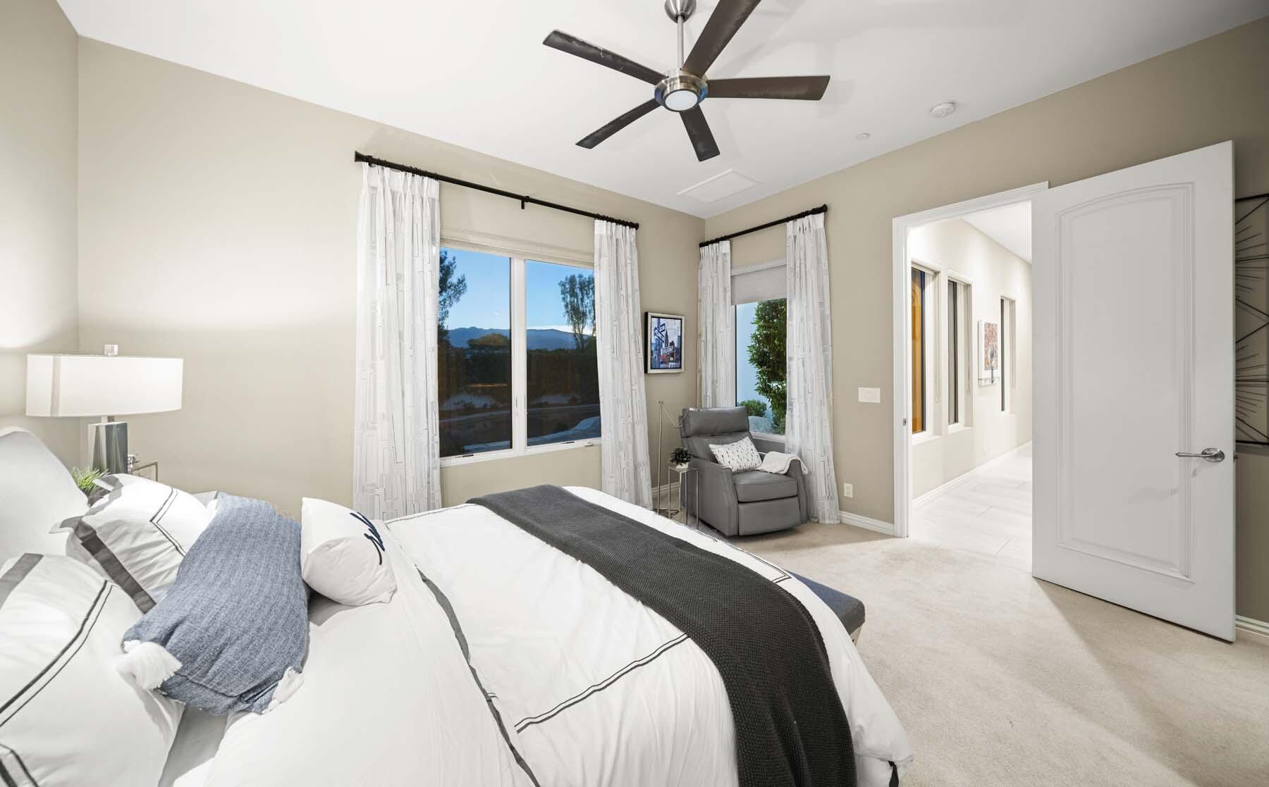 76054 Via Saturnia Indian Wells, CA 92210 - Photo 56 of 61 a bedroom with a large bed and a chandelier
