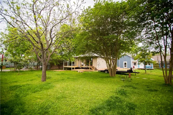 a view of a house with a big yard and large trees