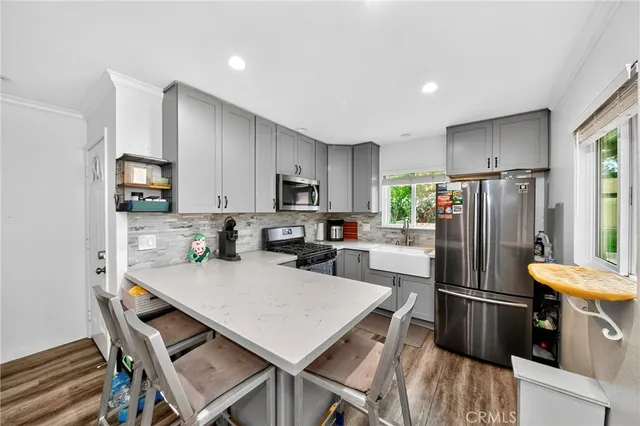 a kitchen with kitchen island a refrigerator stove microwave and cabinets