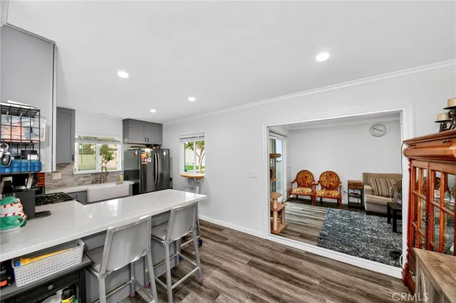 a kitchen with stainless steel appliances wooden floor dining table and chairs