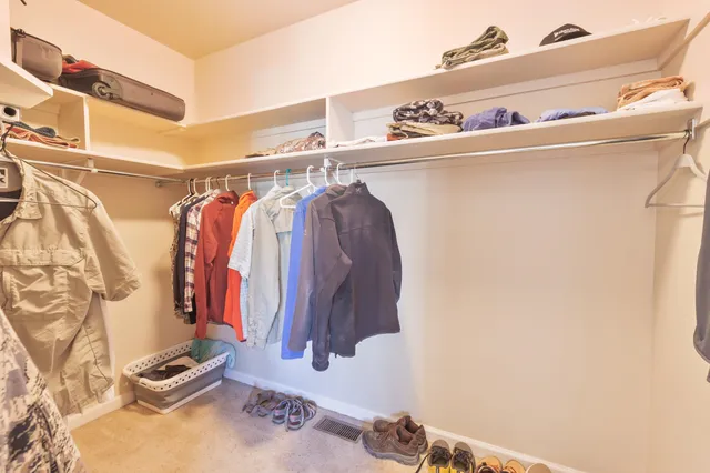 a bathroom with a granite countertop double vanity sink mirror and toilet