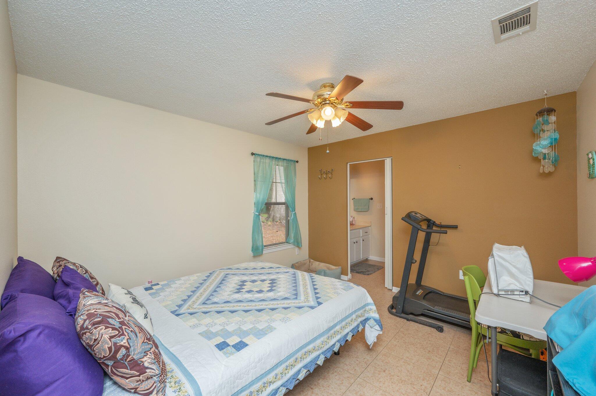 6256 Misty Lane Crestview, FL 32539 - Photo 14 of 39 a bedroom with a bed and a chandelier