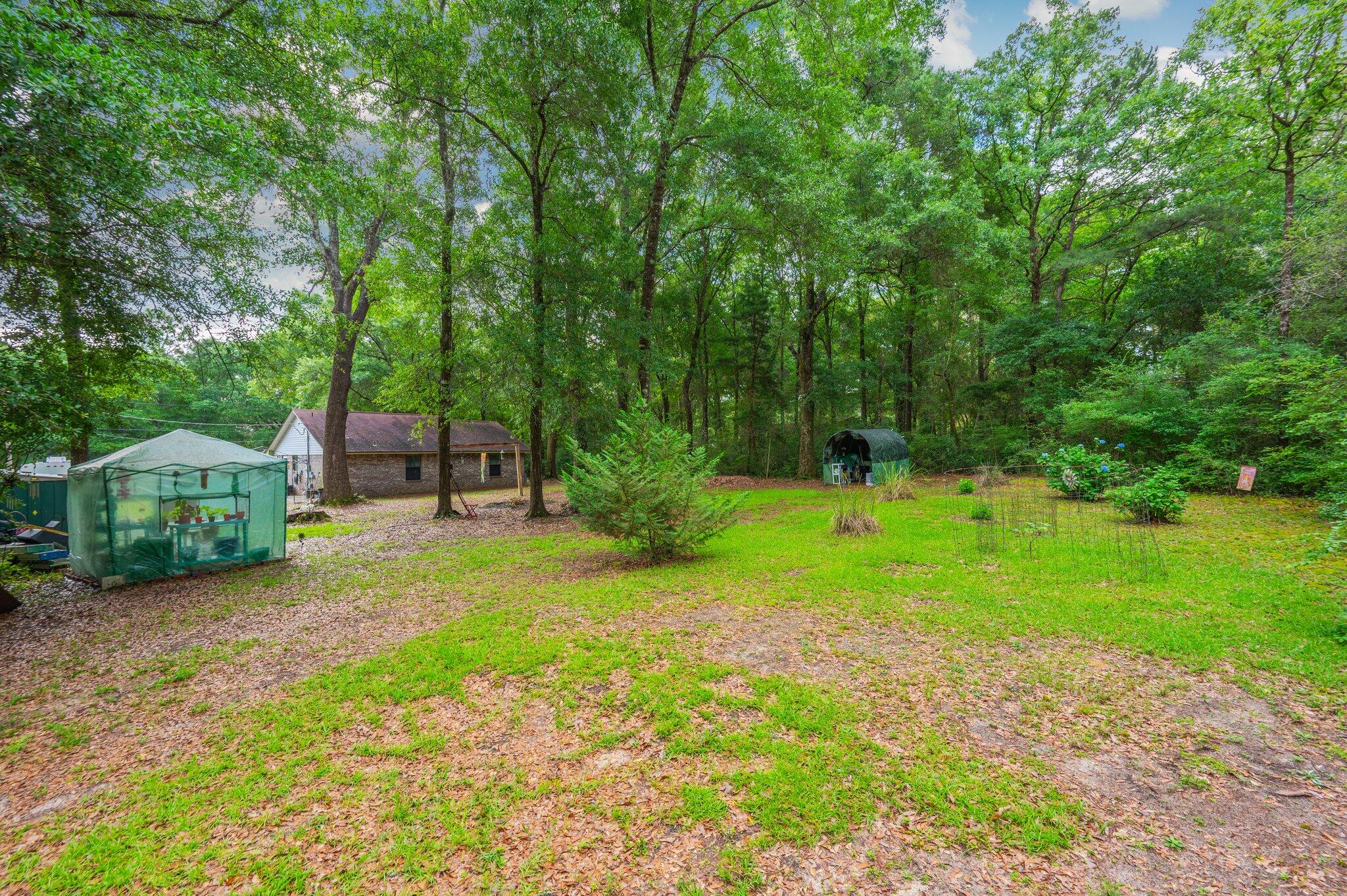 6256 Misty Lane Crestview, FL 32539 - Photo 32 of 39 a backyard of a house with a garden and plants