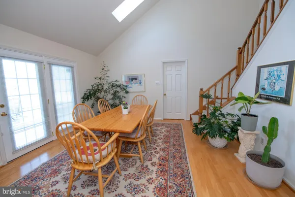 a dining room with furniture potted plants and wooden floor
