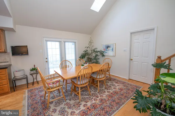 a dining room with furniture potted plants and wooden floor