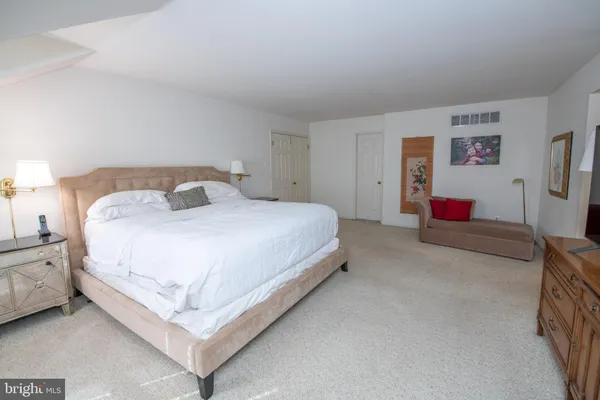 a spacious bedroom with a bed and a couch