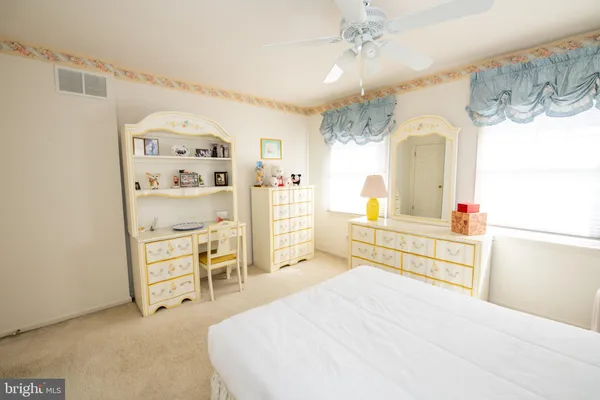 a bedroom with a bed and a lamp on dresser