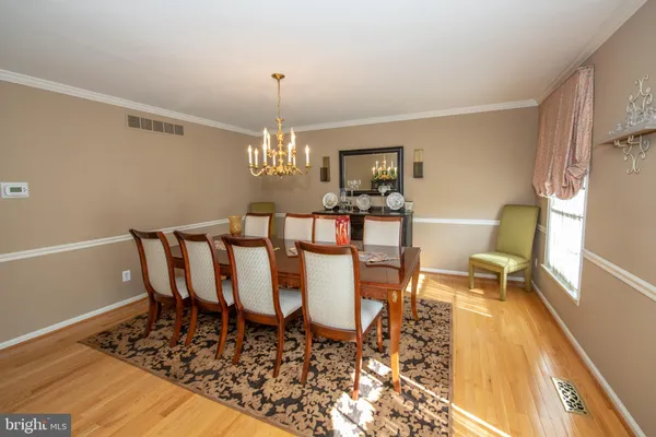a dining room with furniture a chandelier and wooden floor