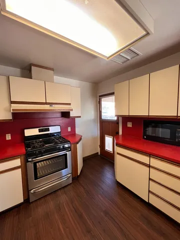 a kitchen with wooden floors and a stove
