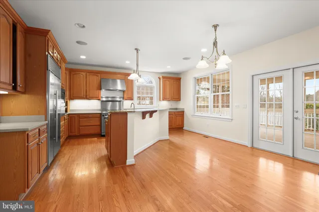 a view of an empty room with wooden floor fireplace and a window
