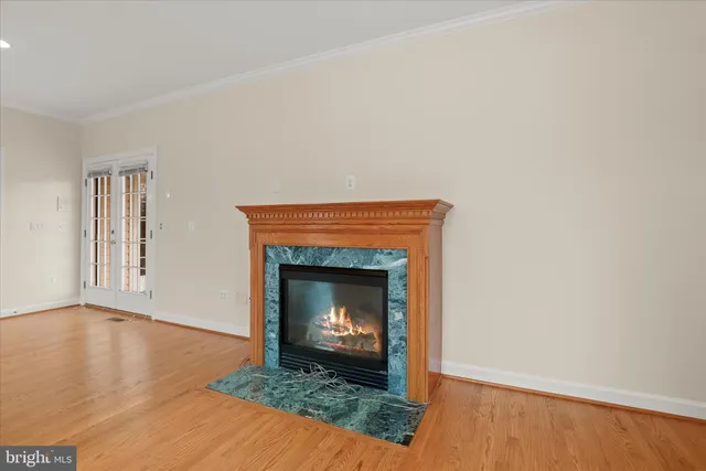 a view of an empty room with wooden floor and windows