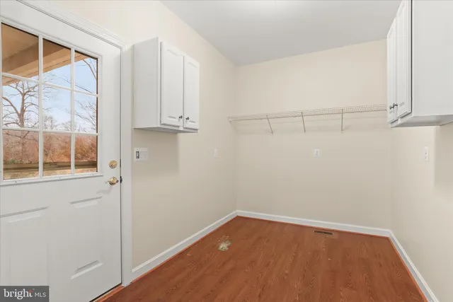 a backyard of a house with table and chairs plants and large tree