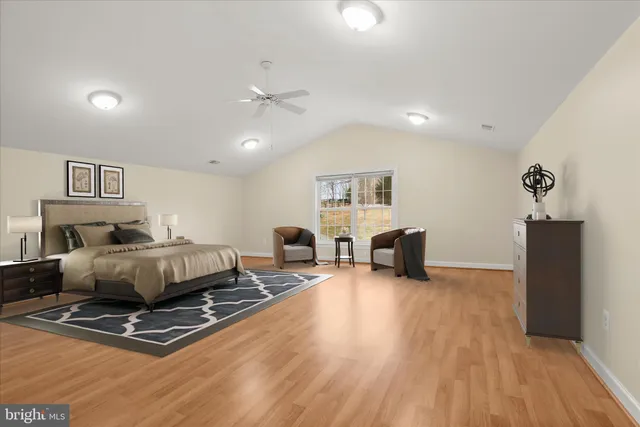 an aerial view of a residential houses with outdoor space and trees all around