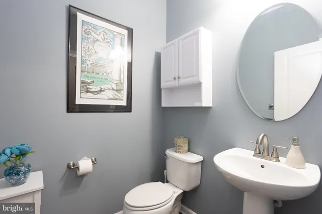 a bathroom with a toilet sink and mirror