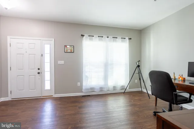 a view of a workspace with furniture and a window