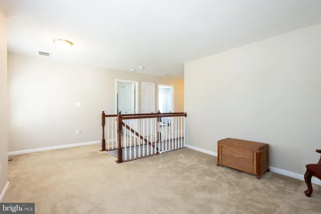 a view of staircase with railing and white walls