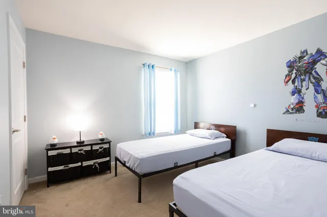 a bedroom with two beds and a potted plant