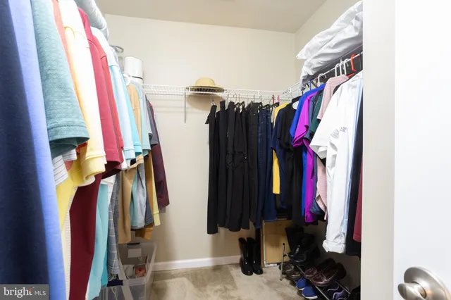 a view of walk in closet with clothes
