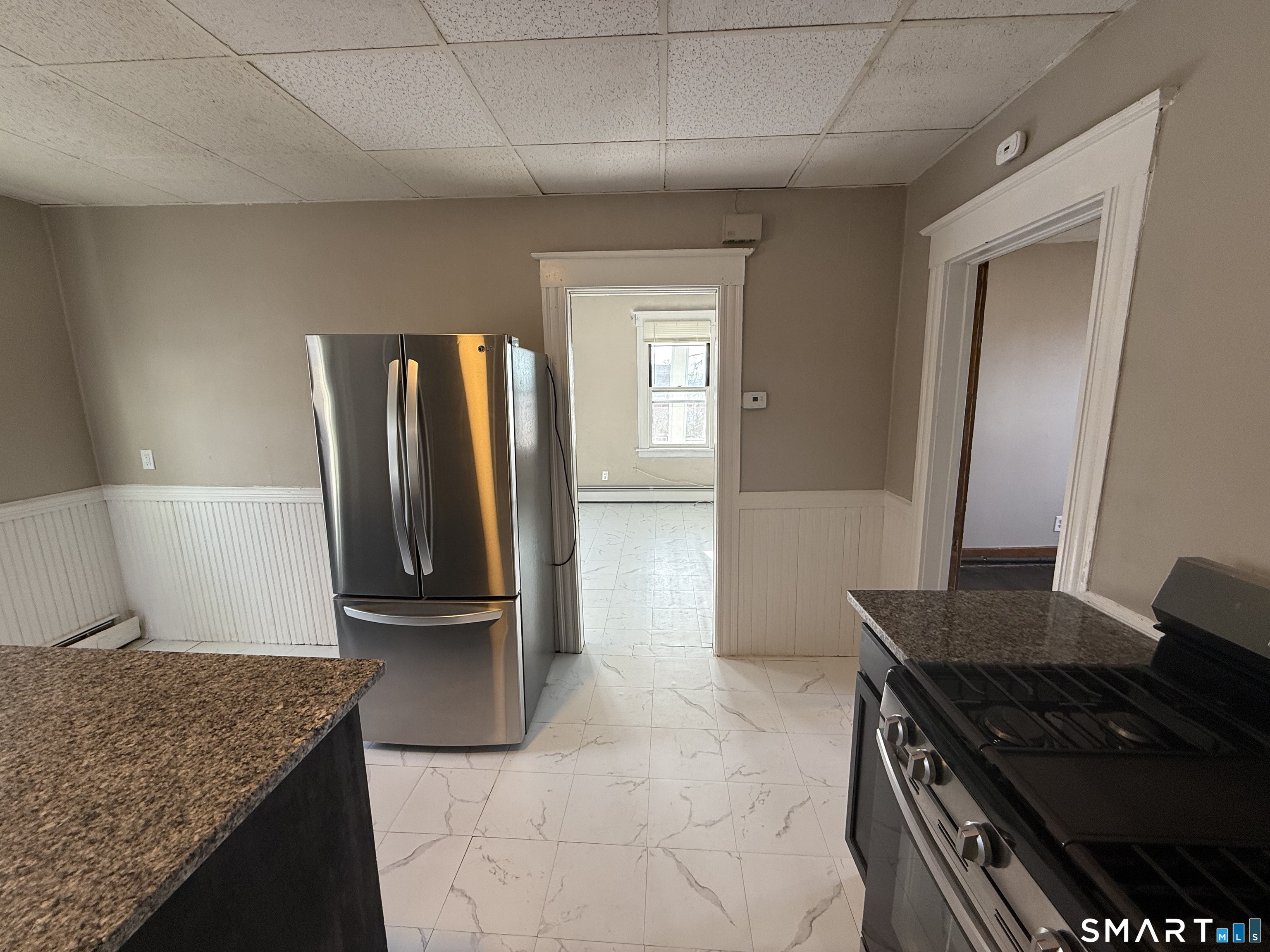 154 Daly Avenue, Unit 3 New Britain, CT 06051 - Photo 12 of 25 a kitchen with granite countertop a refrigerator and a sink