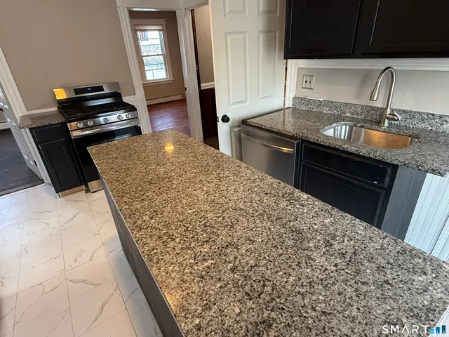 a kitchen with granite countertop stove top oven and sink
