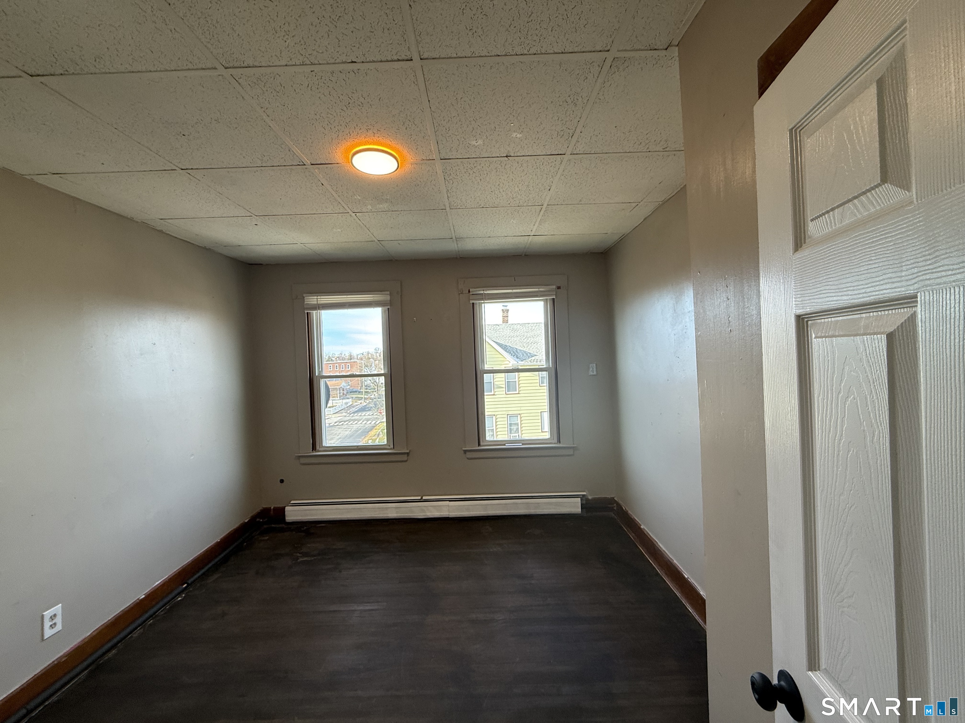 154 Daly Avenue, Unit 3 New Britain, CT 06051 - Photo 21 of 25 an empty room with wooden floor and windows