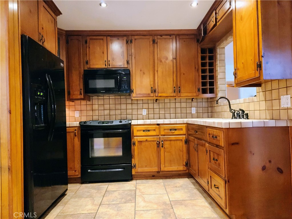 1325 West 34th Street Long Beach, CA 90810 - Photo 3 of 35 a kitchen with stainless steel appliances a stove sink and cabinets