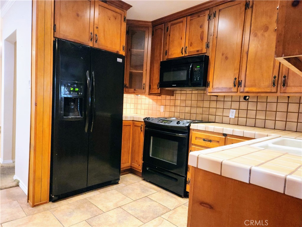 1325 West 34th Street Long Beach, CA 90810 - Photo 4 of 35 a kitchen with stainless steel appliances kitchen island granite countertop a refrigerator and a stove top oven
