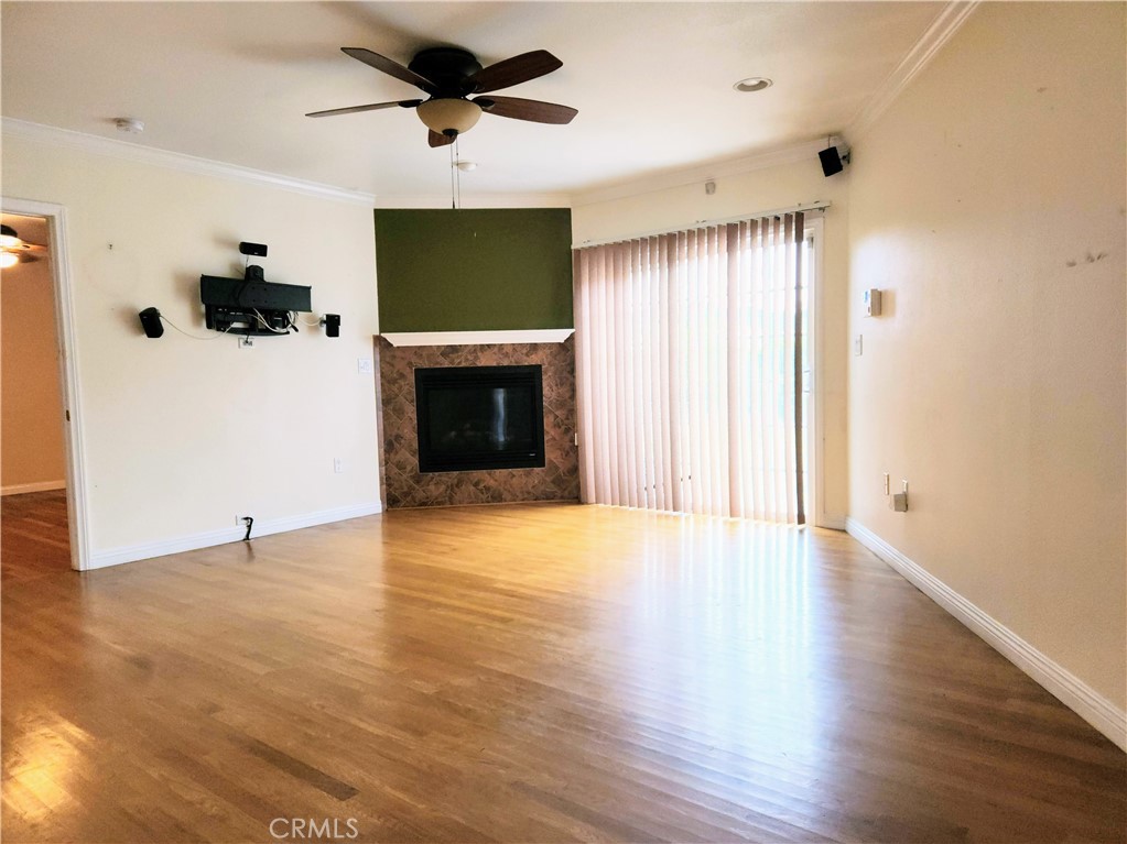 1325 West 34th Street Long Beach, CA 90810 - Photo 8 of 35 a view of a livingroom with a fireplace a ceiling fan and window