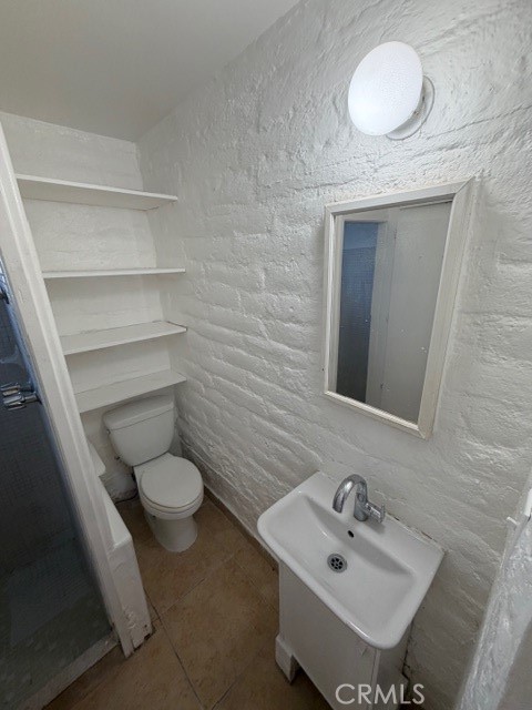 66351 First Street, Unit 2 Desert Hot Springs, CA 92240 - Photo 13 of 16 a bathroom with a sink toilet and mirror