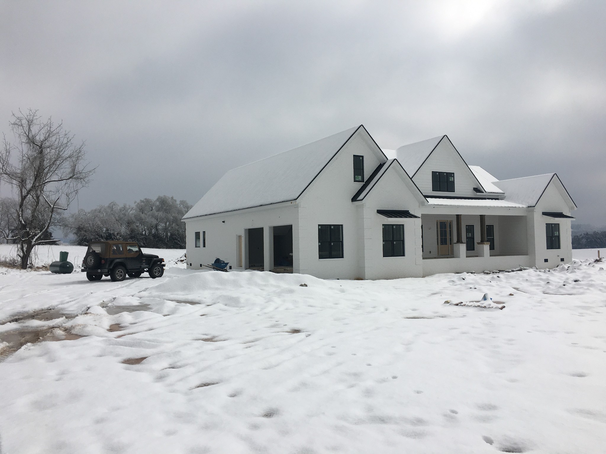 a front view of a house with a yard covered in snow