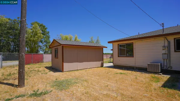 a view of a house with backyard and wooden fence