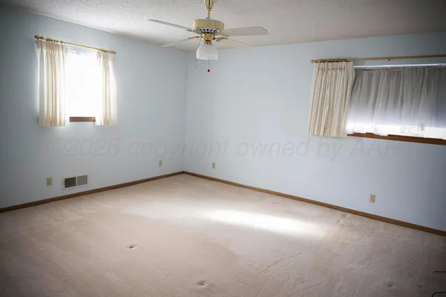 an empty room with chandelier fan