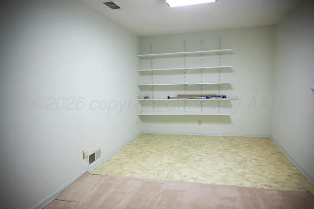 a backyard of a house with large trees and brick walls