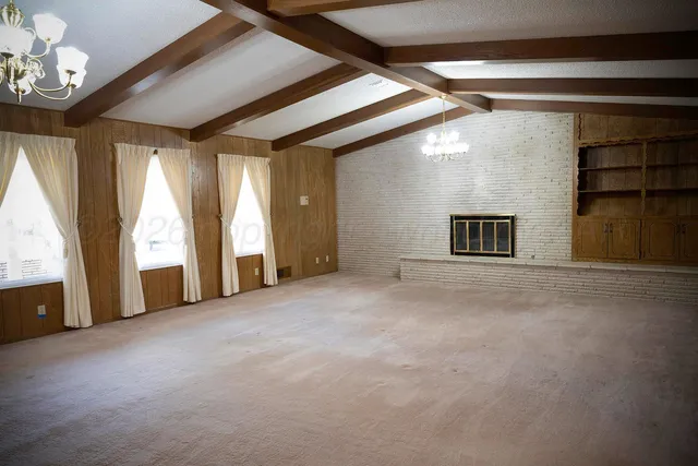 an empty room with a fireplace and fan