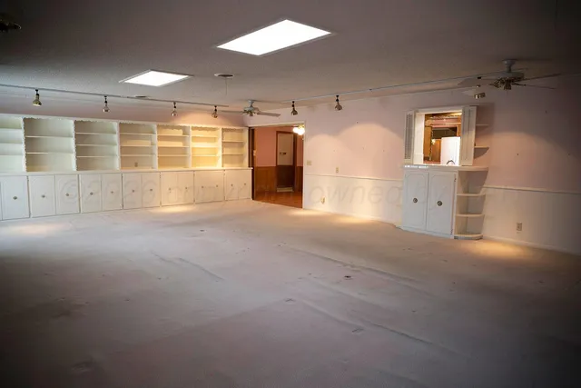 an empty room with a fireplace cabinet and window