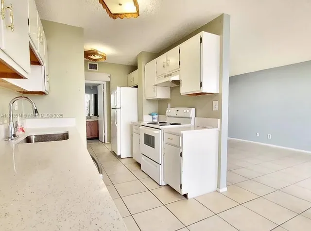 a kitchen with white cabinets and white appliances