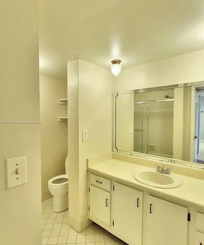 a bathroom with a double vanity sink toilet and a mirror