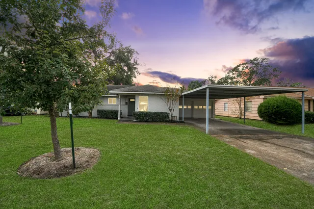 a view of a house with a yard and tree s