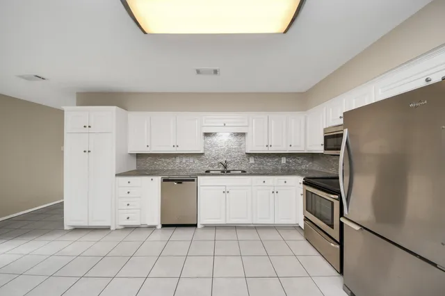 a kitchen with stainless steel appliances granite countertop a refrigerator and a stove