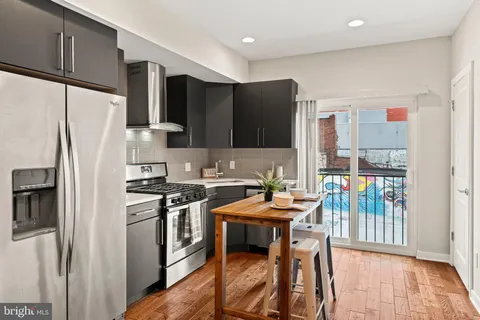 a kitchen with stainless steel appliances a stove a refrigerator a sink and a stove