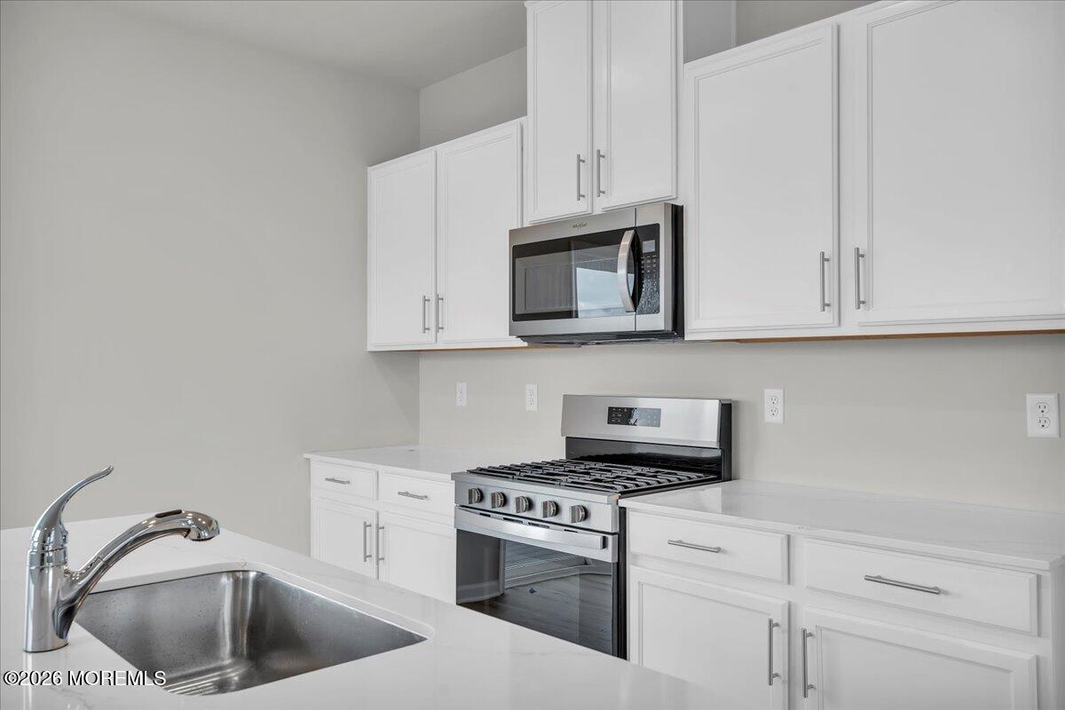 216 Sandy Rdg Road Sicklerville, NJ 08081 - Photo 8 of 24 a kitchen with white cabinets stainless steel appliances and sink