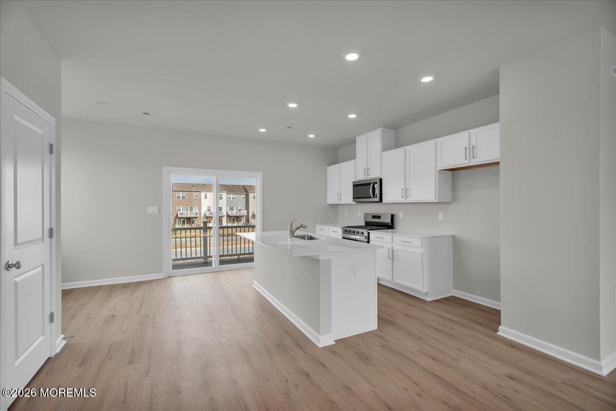 216 Sandy Rdg Road Sicklerville, NJ 08081 - Photo 10 of 24 a kitchen with white cabinets and wooden floor