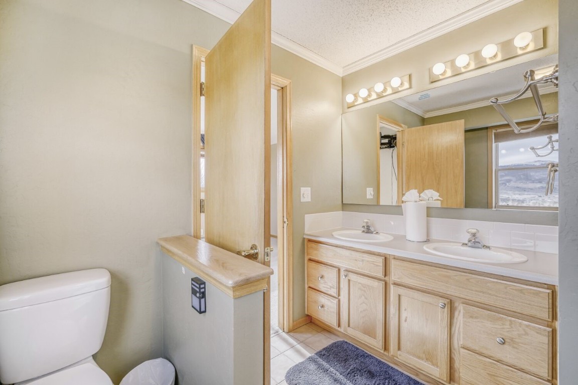 63 20 Grand Court, Unit 63 Silverthorne, CO 80498 - Photo 25 of 28 a bathroom with a granite countertop sink mirror vanity and toilet
