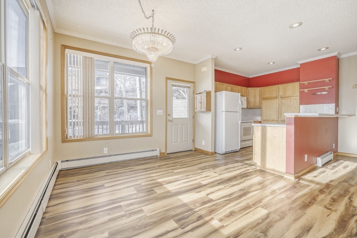 63 20 Grand Court, Unit 63 Silverthorne, CO 80498 - Photo 6 of 28 a view of a kitchen with a refrigerator a microwave and a ceiling fan