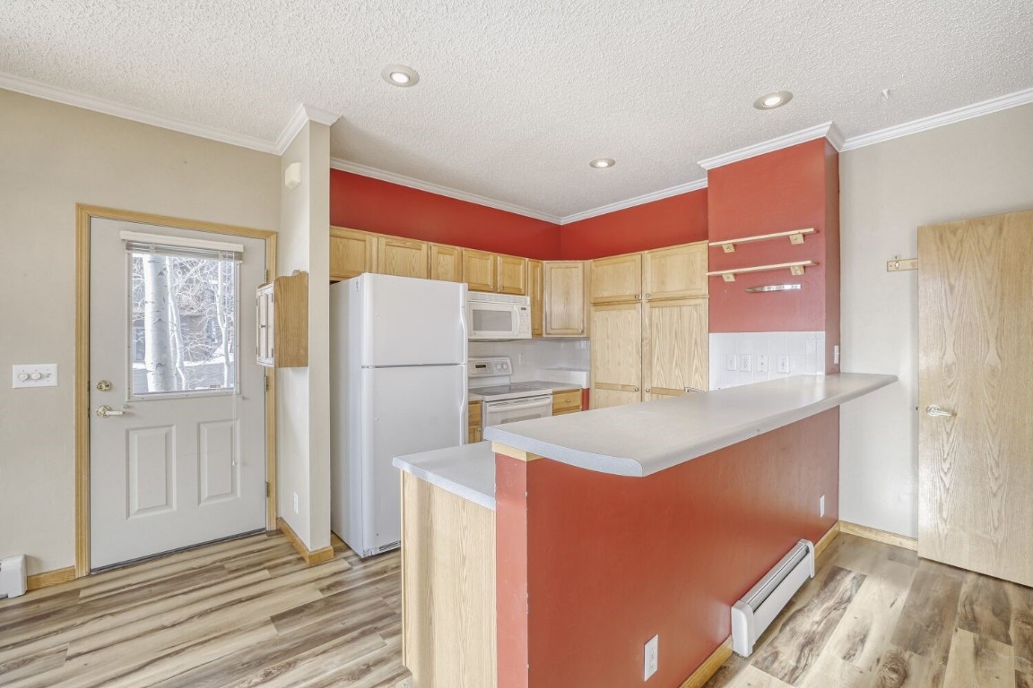 63 20 Grand Court, Unit 63 Silverthorne, CO 80498 - Photo 10 of 28 a kitchen with a refrigerator a sink and cabinets